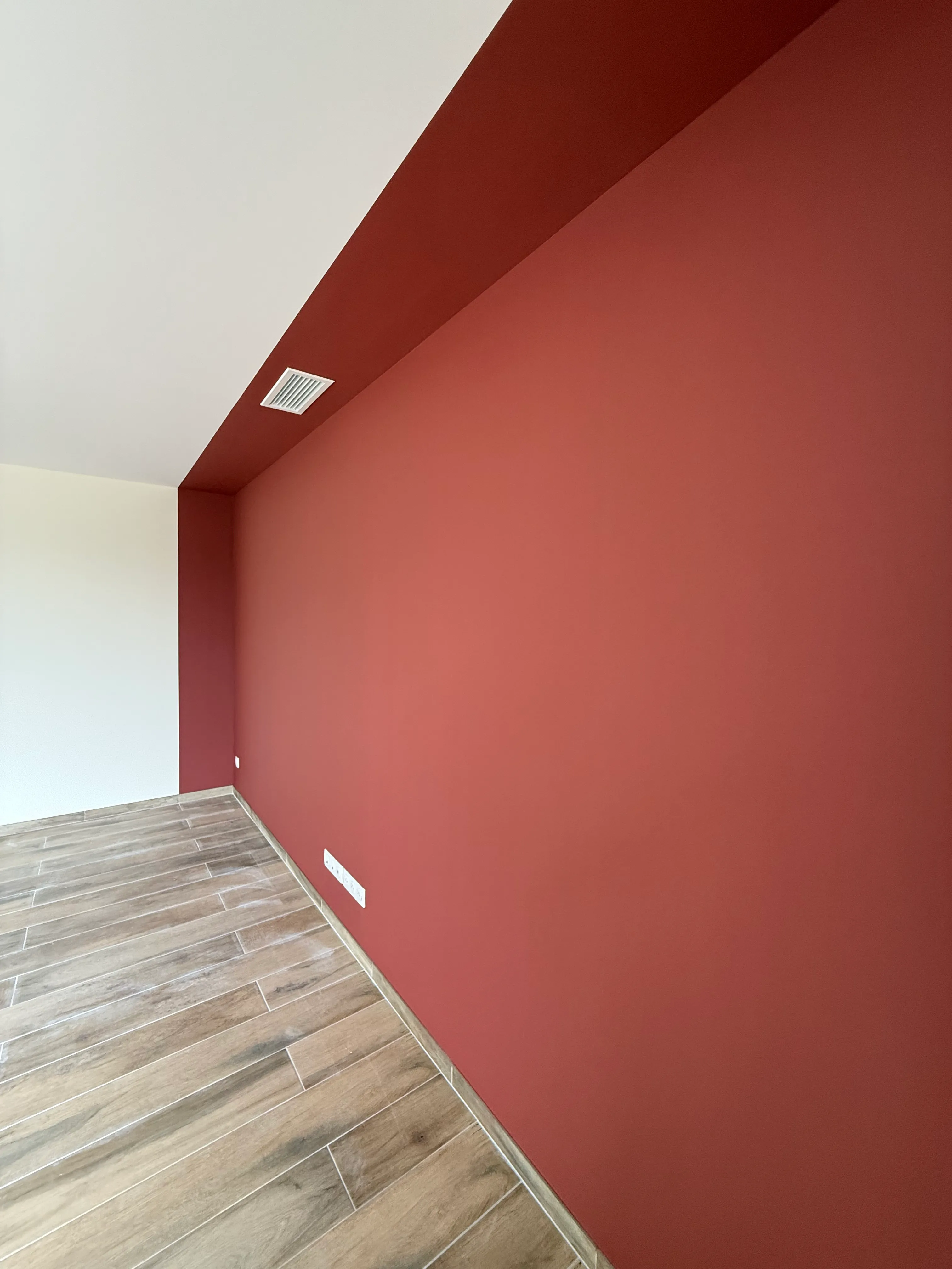 Mur accent terracota intense avec plafond blanc — finition mate, peinture intérieure réalisée dans l'Aude