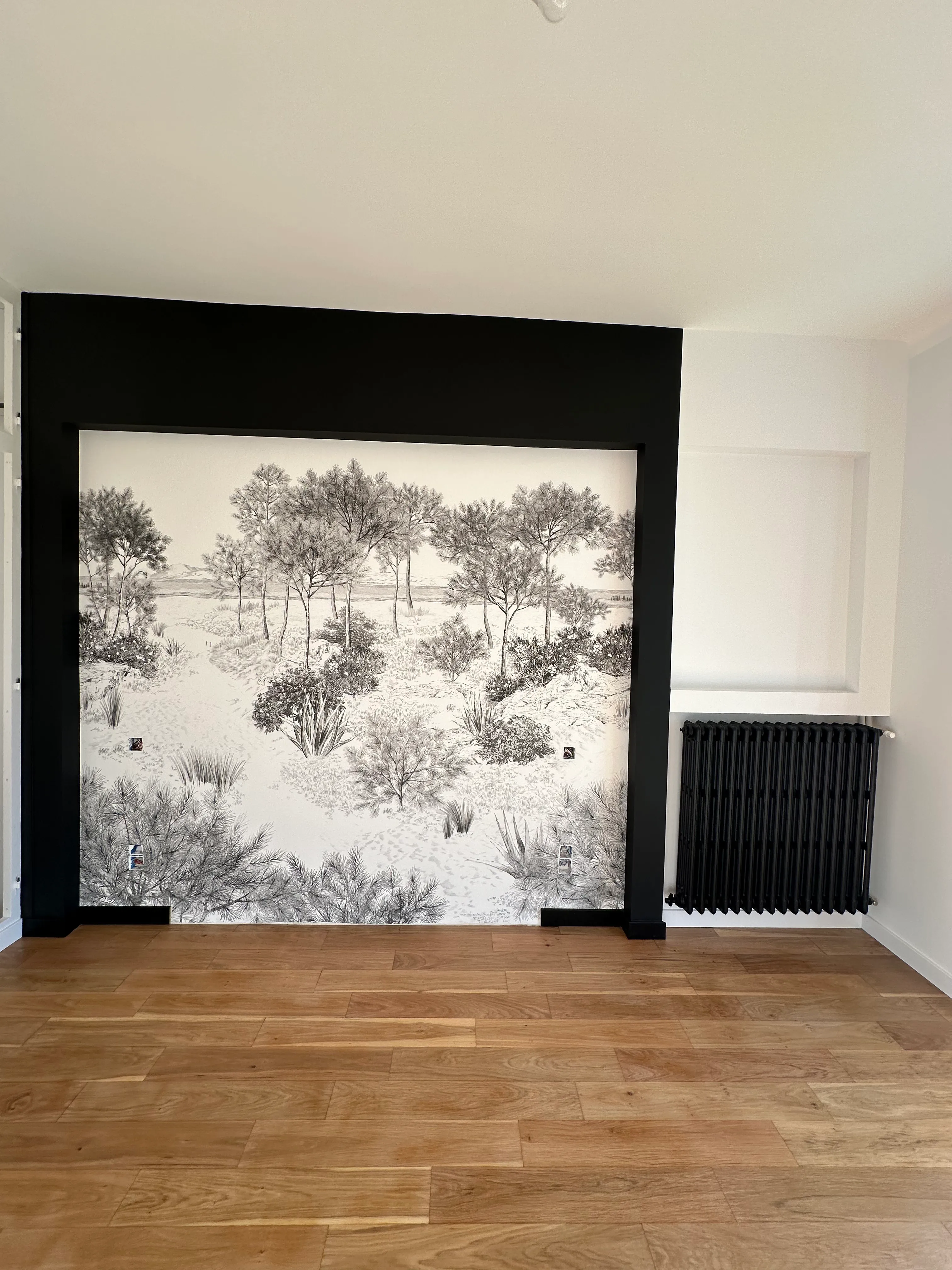 Artisan posant un revêtement mural avec précision — raccord soigné, chantier LK Peinture Alairac