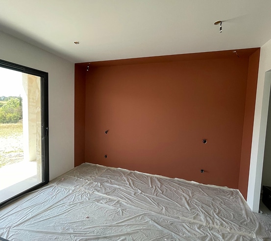 Peintre avec rouleau à peinture : préparation travaux Gros plan sur la main d'un peintre portant un gant blanc, tenant fermement le manche d'un rouleau à peinture neuf, en préparation d'une rénovation.
