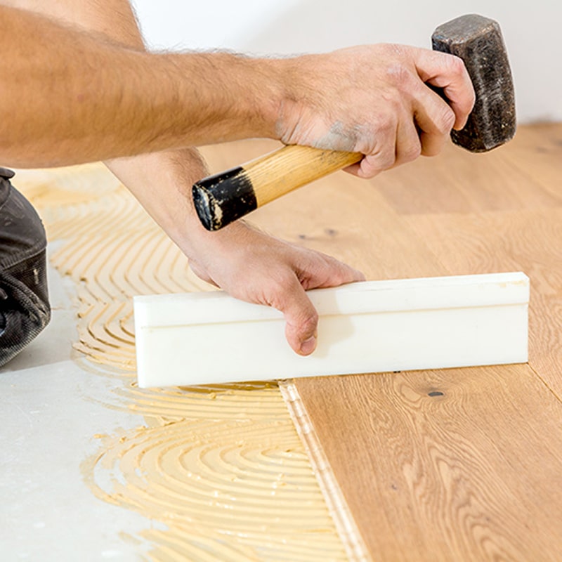 Peintre avec rouleau à peinture : préparation travaux Gros plan sur la main d'un peintre portant un gant blanc, tenant fermement le manche d'un rouleau à peinture neuf, en préparation d'une rénovation.