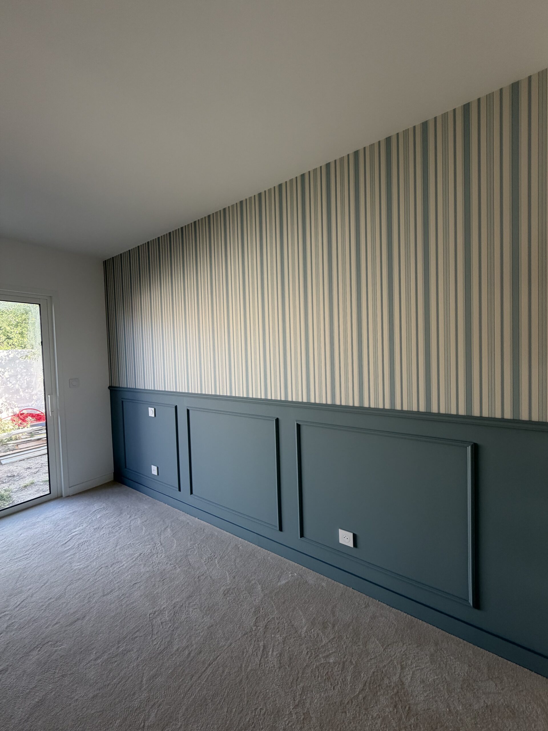 Peintre avec rouleau à peinture : préparation travaux Gros plan sur la main d'un peintre portant un gant blanc, tenant fermement le manche d'un rouleau à peinture neuf, en préparation d'une rénovation.